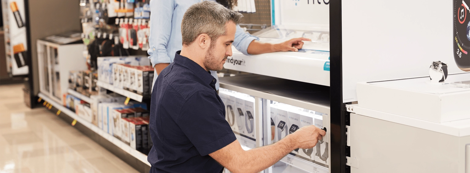 Un dependiente monta un expositor de forma segura en una gran superficie comercial