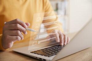 Un gerente de tienda completa una lista de verificación de auditoría de prevención de pérdidas en una computadora portátil.