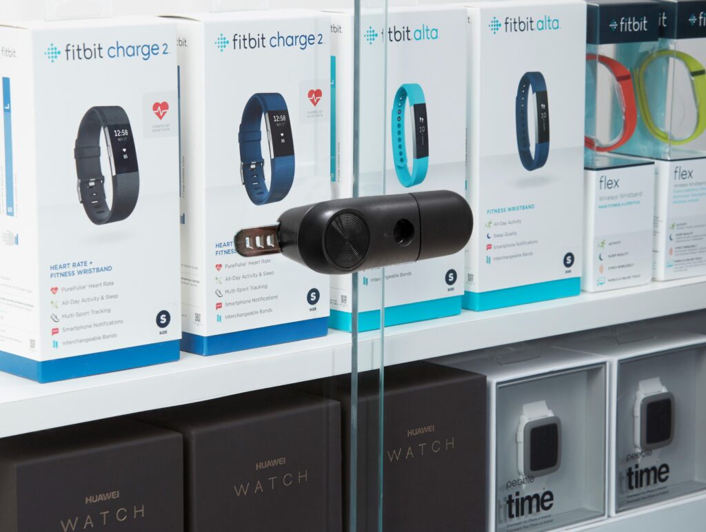 Primer plano de un cierre deslizante « InVue  »LIVE que asegura las puertas correderas de cristal de una vitrina para dispositivos wearables