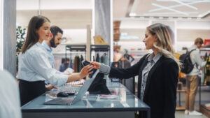 Un dependiente tramita la devolución de un cliente en el mostrador de la tienda, lo que pone de manifiesto la importancia de los procedimientos de verificación de devoluciones para evitar devoluciones fraudulentas y pérdidas de inventario.