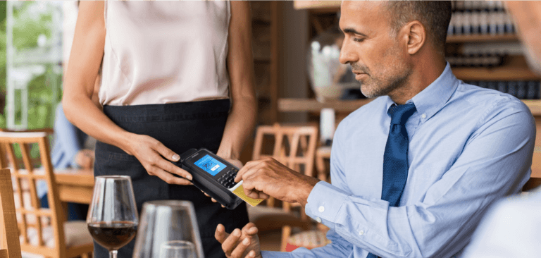 Hombre usando mPOS Handheld Case para completar el pago en un restaurante.