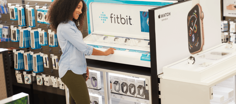 Mujer en un expositor de Fitbit en una tienda