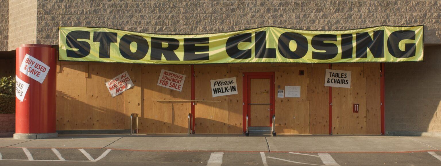 Imagen de una gran tienda con un cartel en la fachada anunciando "cierre de la tienda"